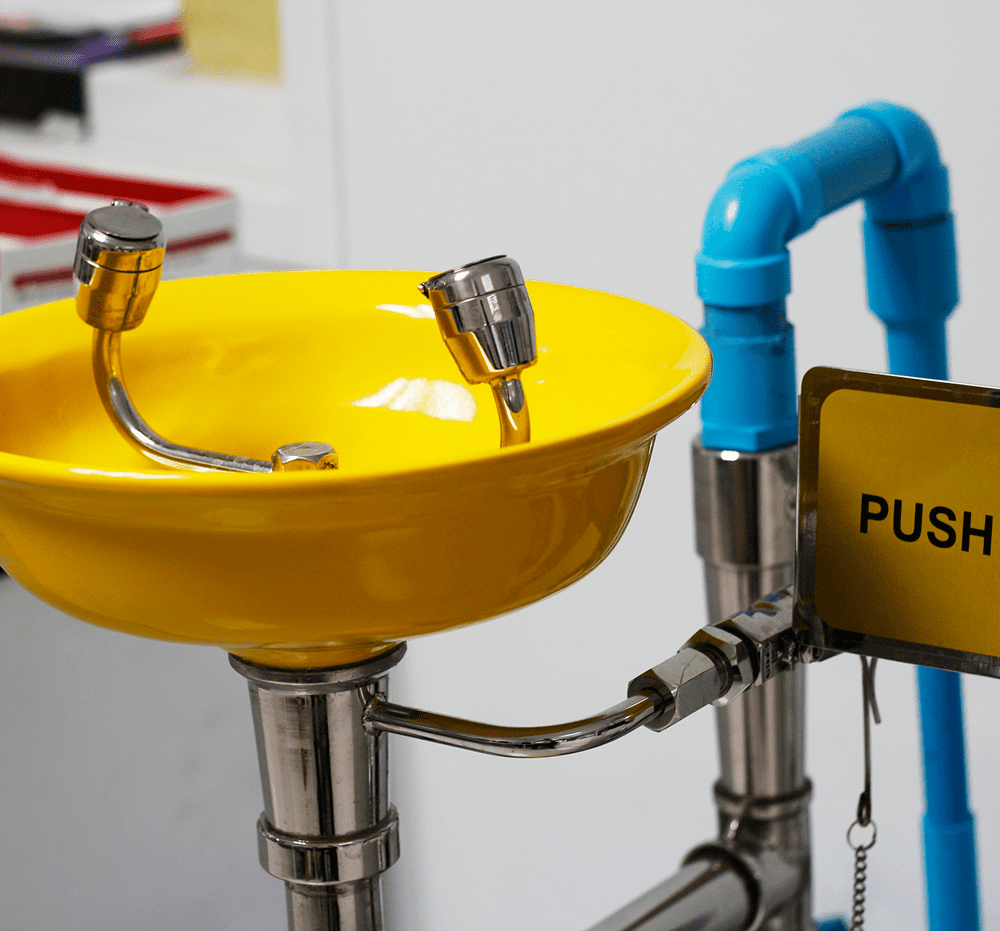 Yellow safety eyewash station with push sign